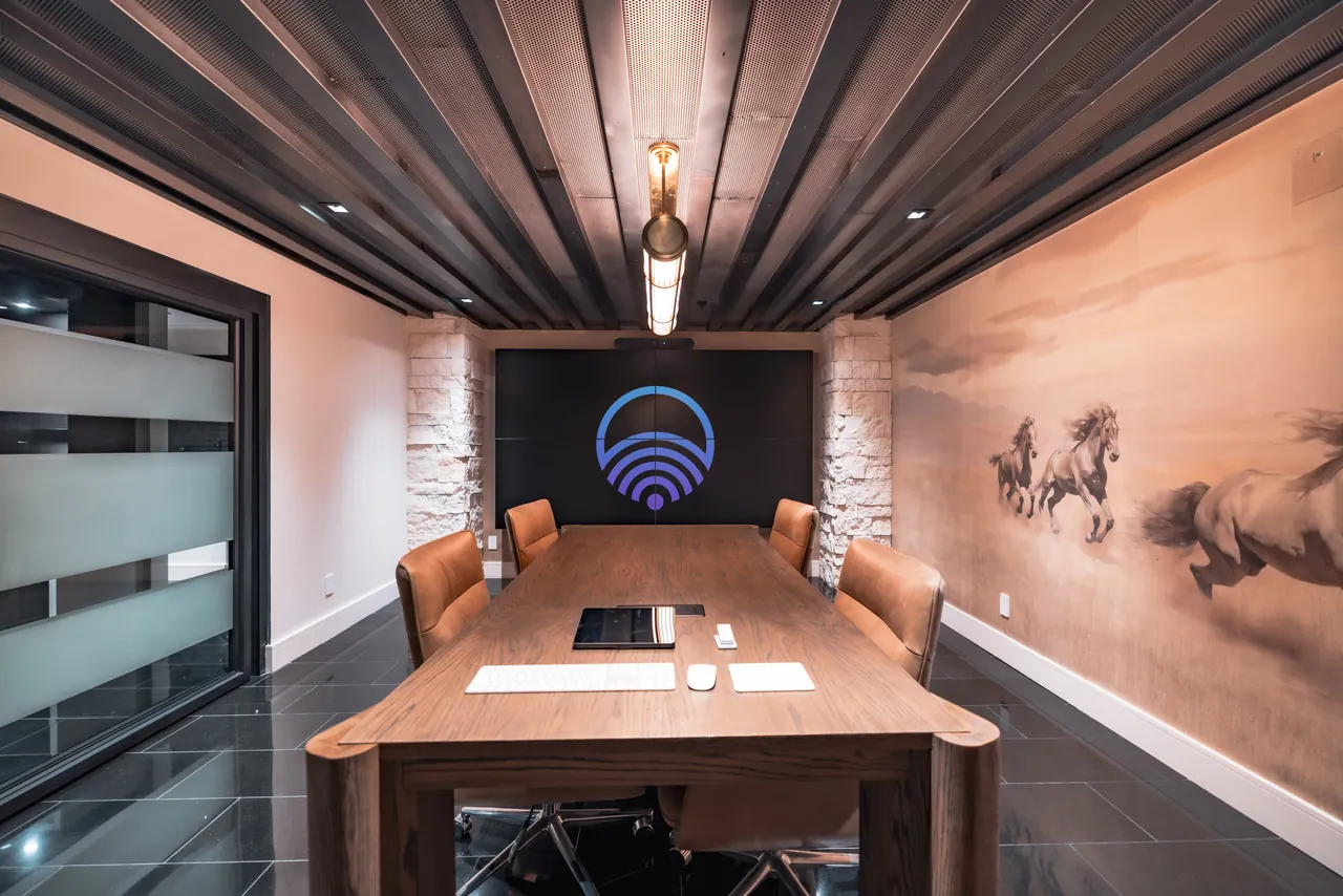 Executive boardroom with a video wall, stone columns and leather seating