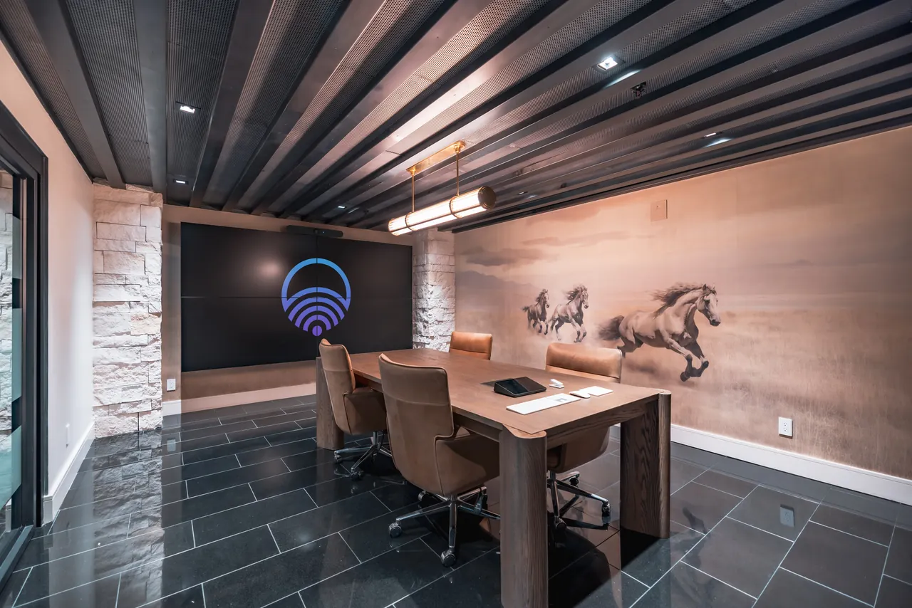 Boardroom with layered architectural lighting and a brass pendant fixture
