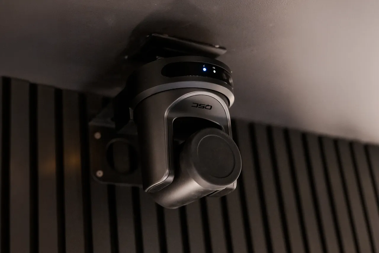 Ceiling-mounted pan-tilt-zoom security camera in a dark commercial interior