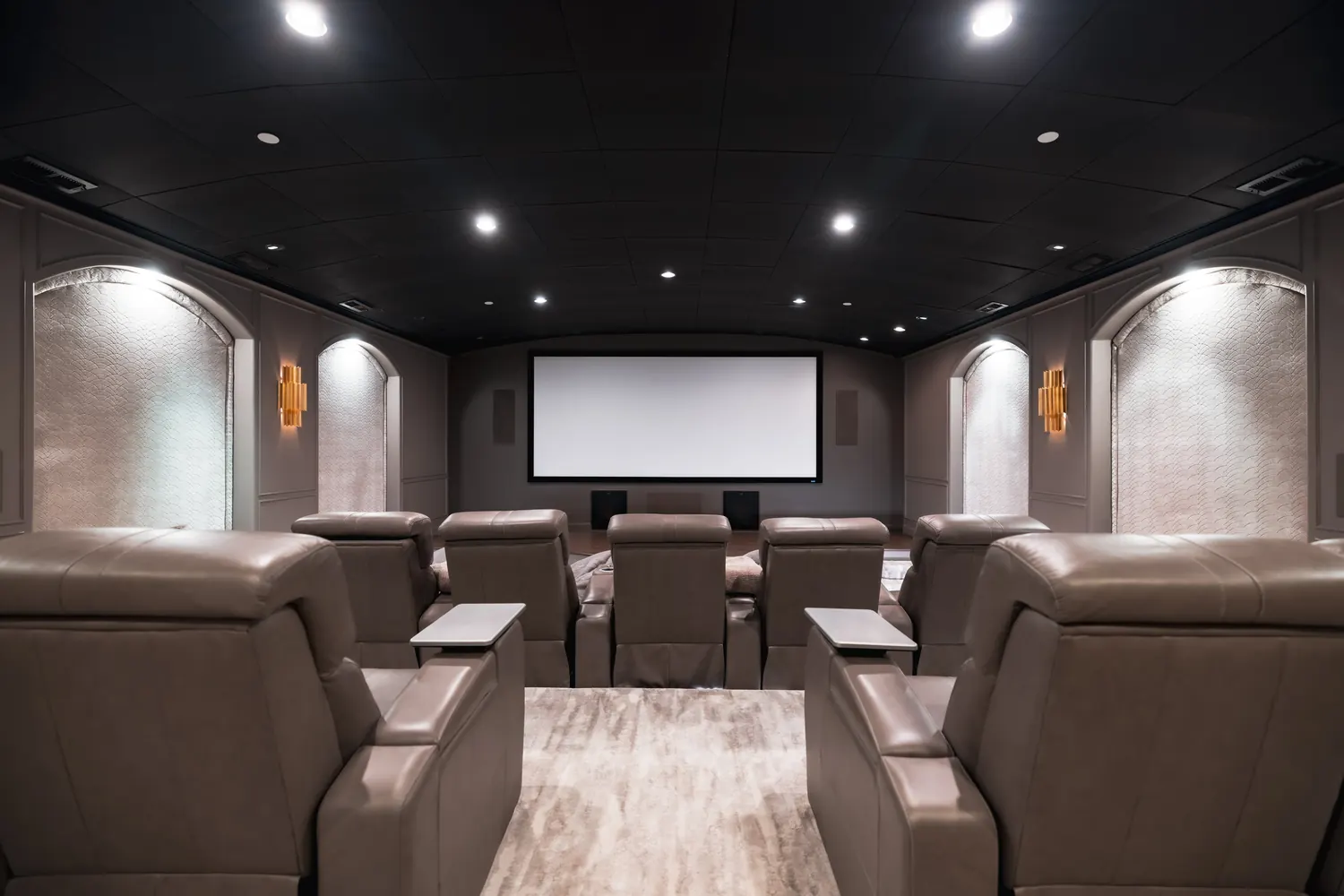 Private cinema with tiered leather seating, acoustic arches and a wide screen