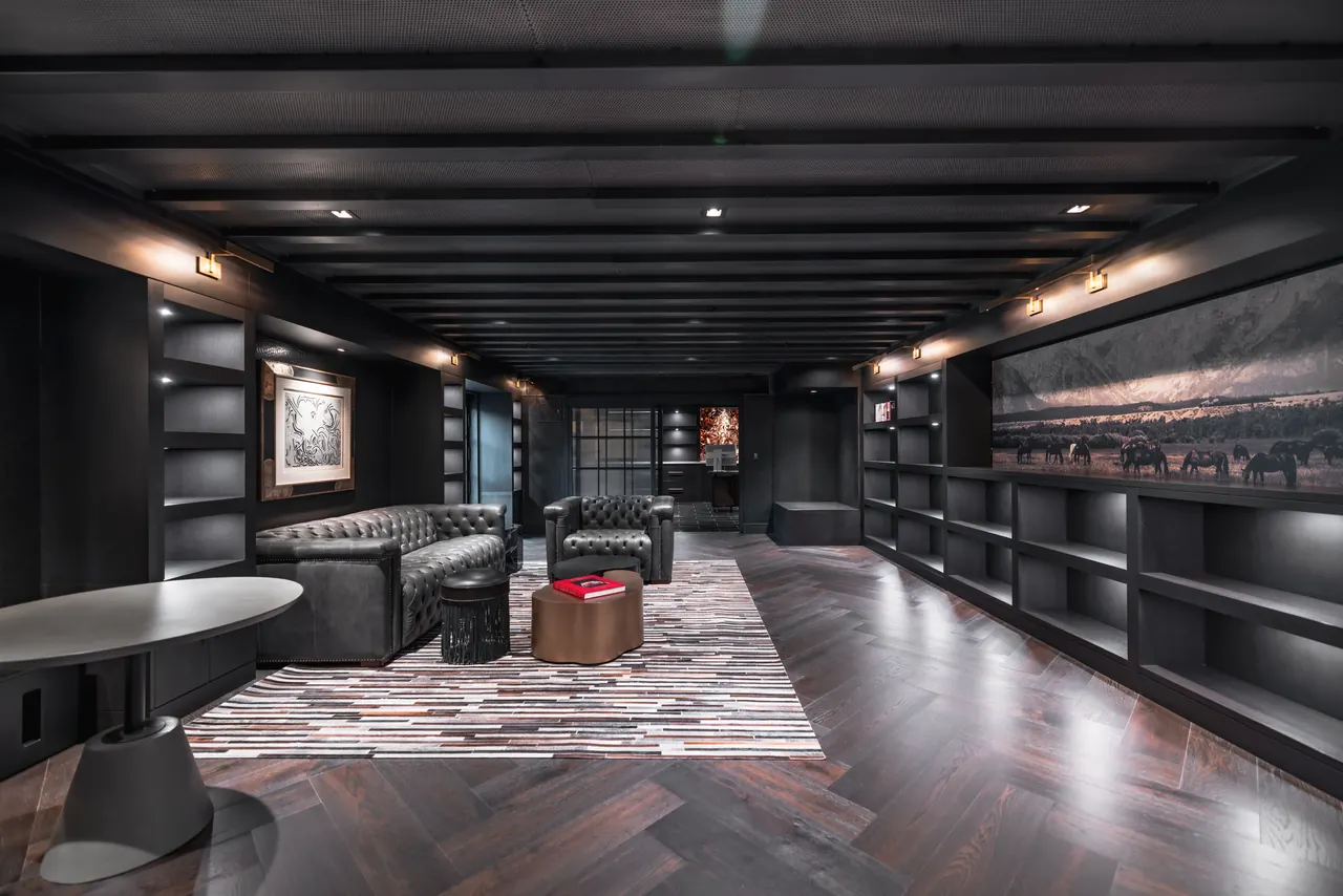Blacked-out owner's lounge with concealed in-ceiling speakers and layered accent lighting