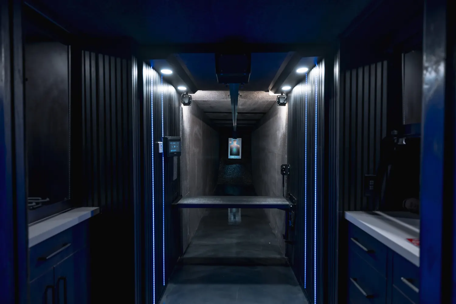 Private indoor shooting range with blue LED strips and a wall touch panel