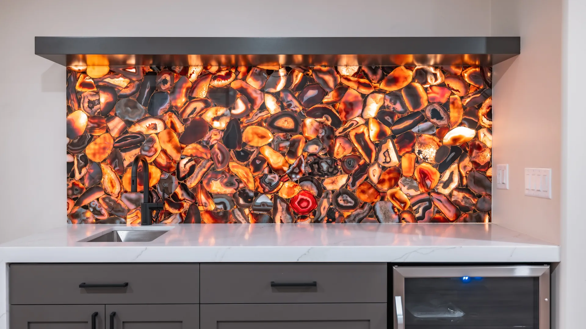 Home bar with a backlit agate feature wall and stone counter
